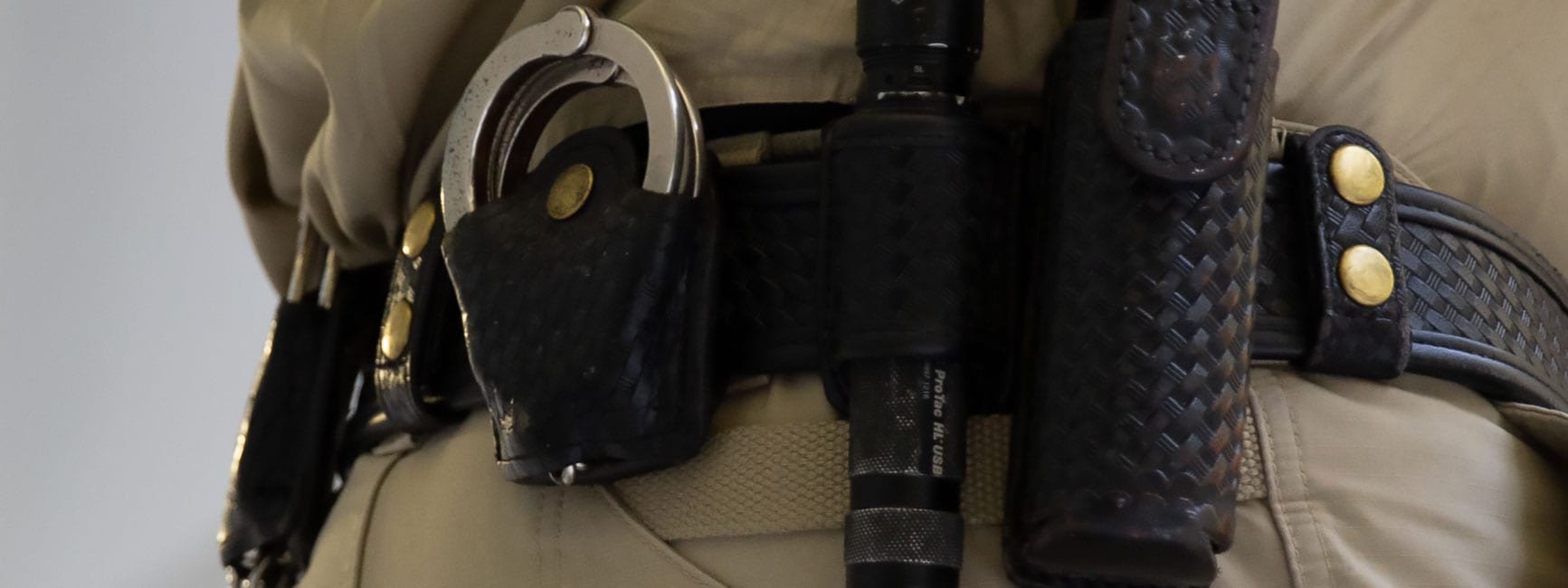 The belt of a security officer with handcuff and flashlight and other tools.