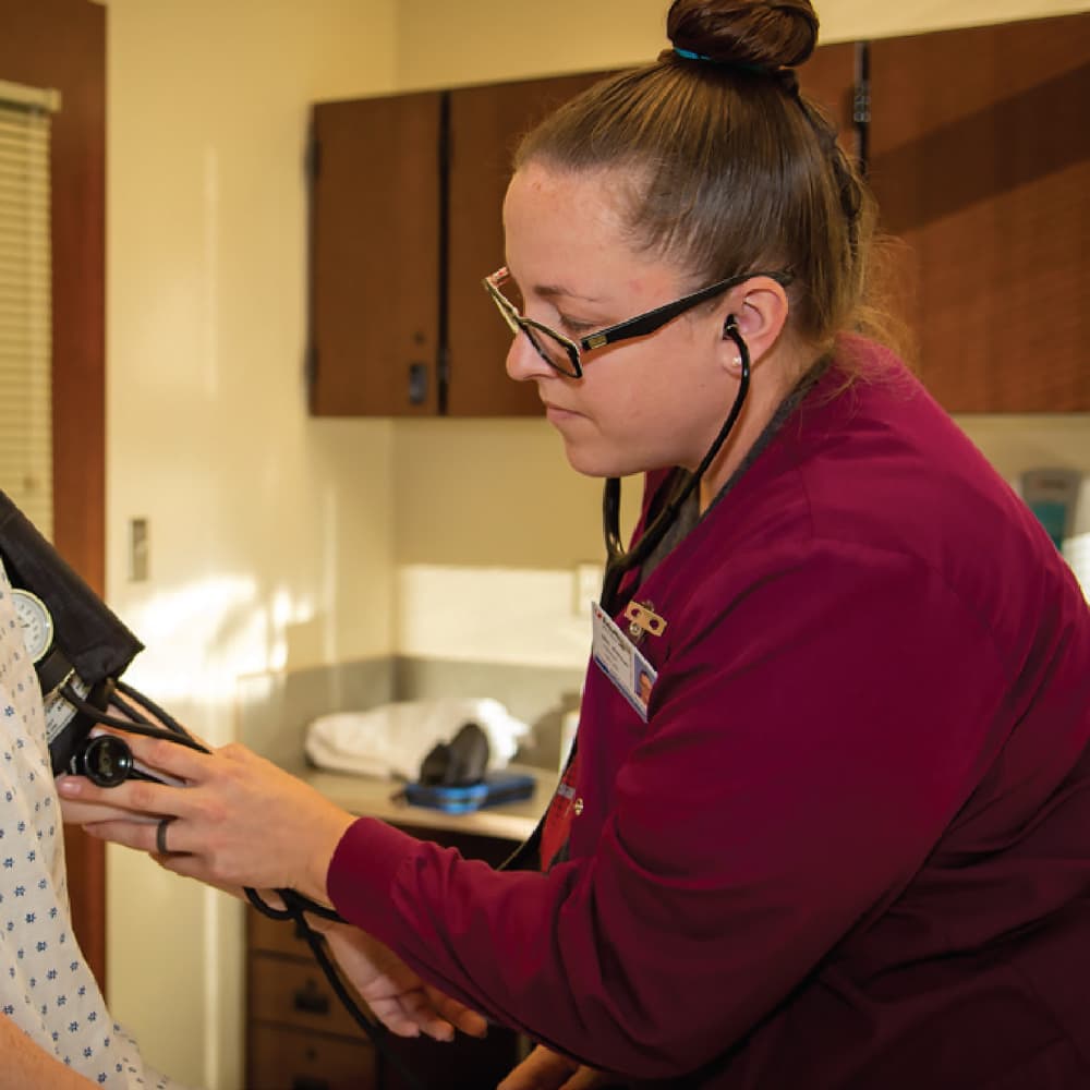 A Health Sciences student takes a subject's blood pressure.